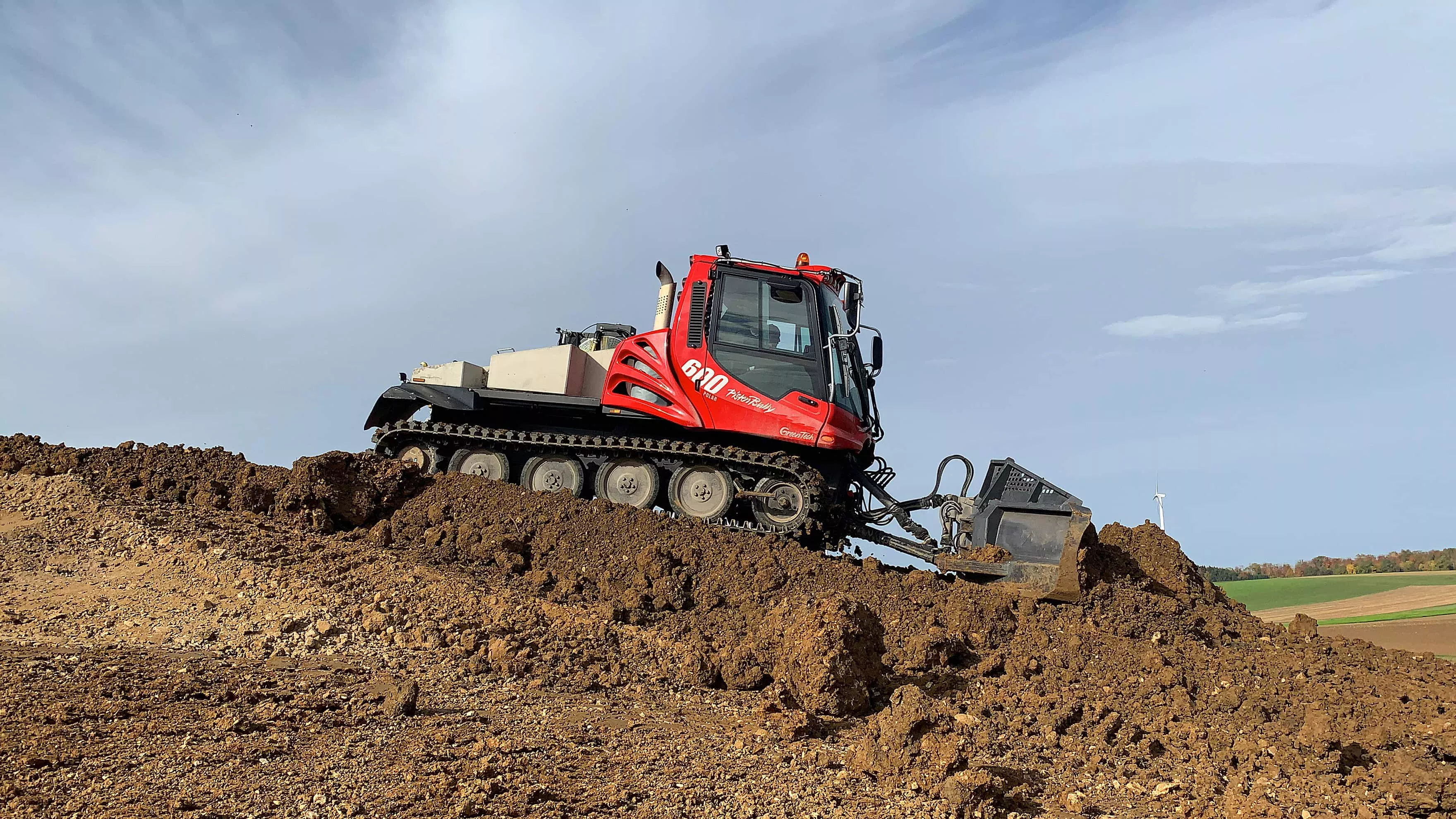 PistenBully 600 Polar GreenTech beim Verschieben von Erde.