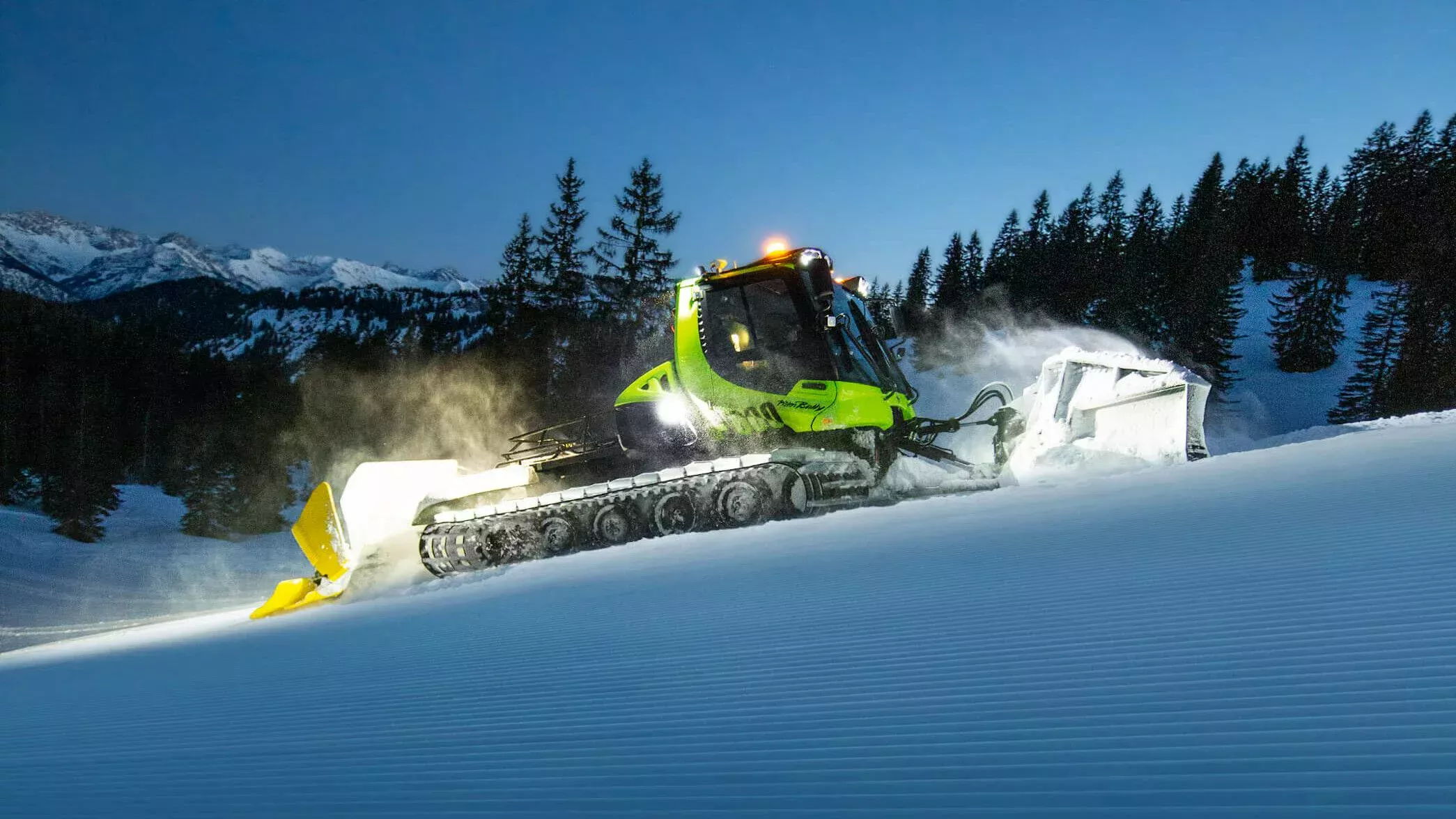 PistenBully 600 E+ en action sur la montagne, de nuit