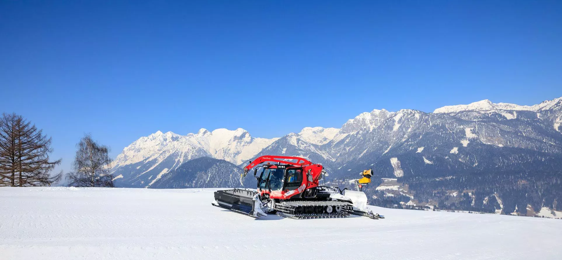 PistenBully 600 Polar W devant un magnifique panorama de montagne