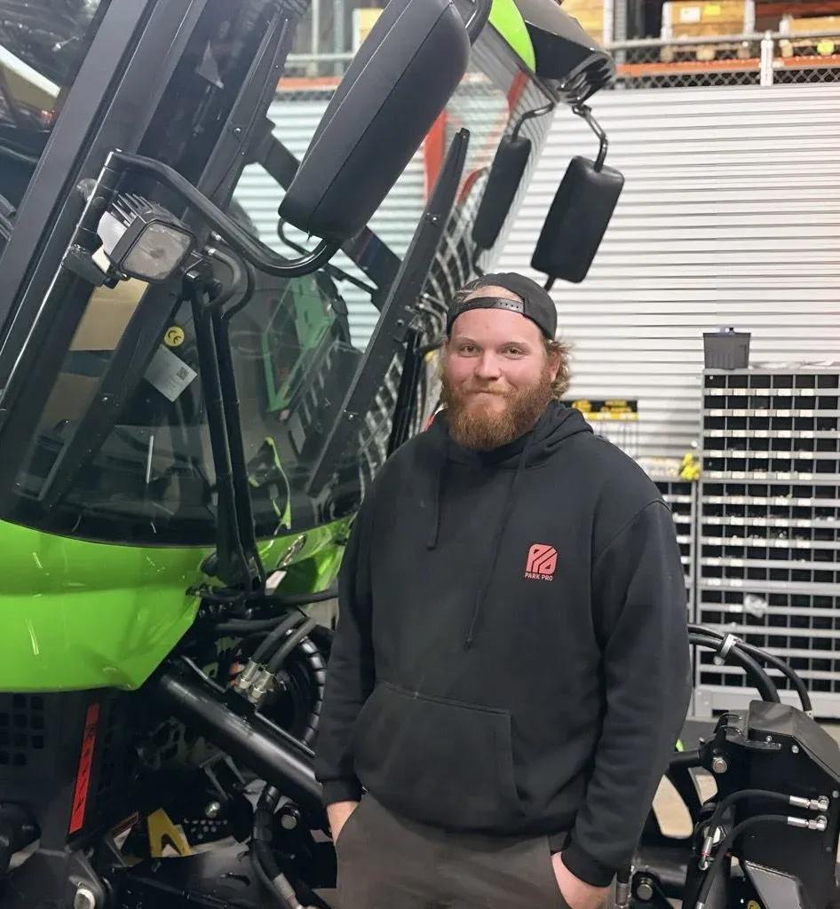 PistenBully service technician Logan Fulton in front of a 600E+.