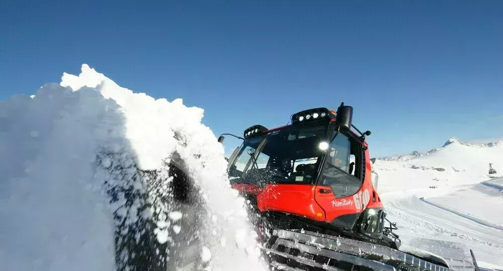 PistenBully 600 Polar schiebt Schnee mit dem Schild.