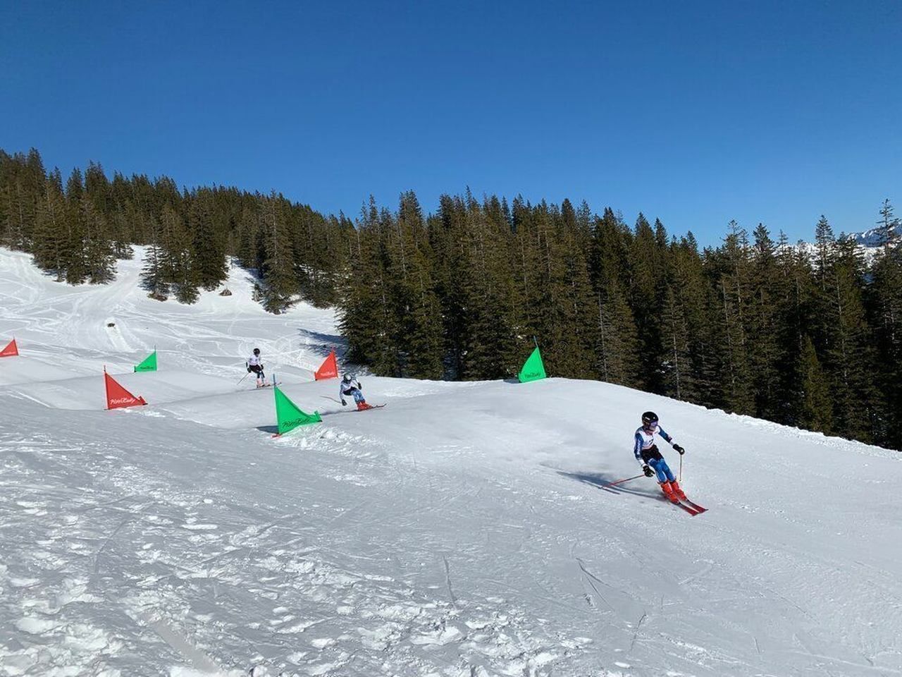 Die Kids fahren die Skicross Strecke hinunter