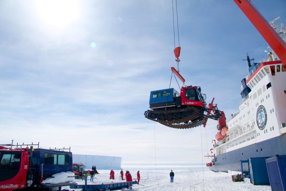 PistenBully 300 Polar Antarktis wird auf das Forschungsschiff mit dem Kran verfrachtet.