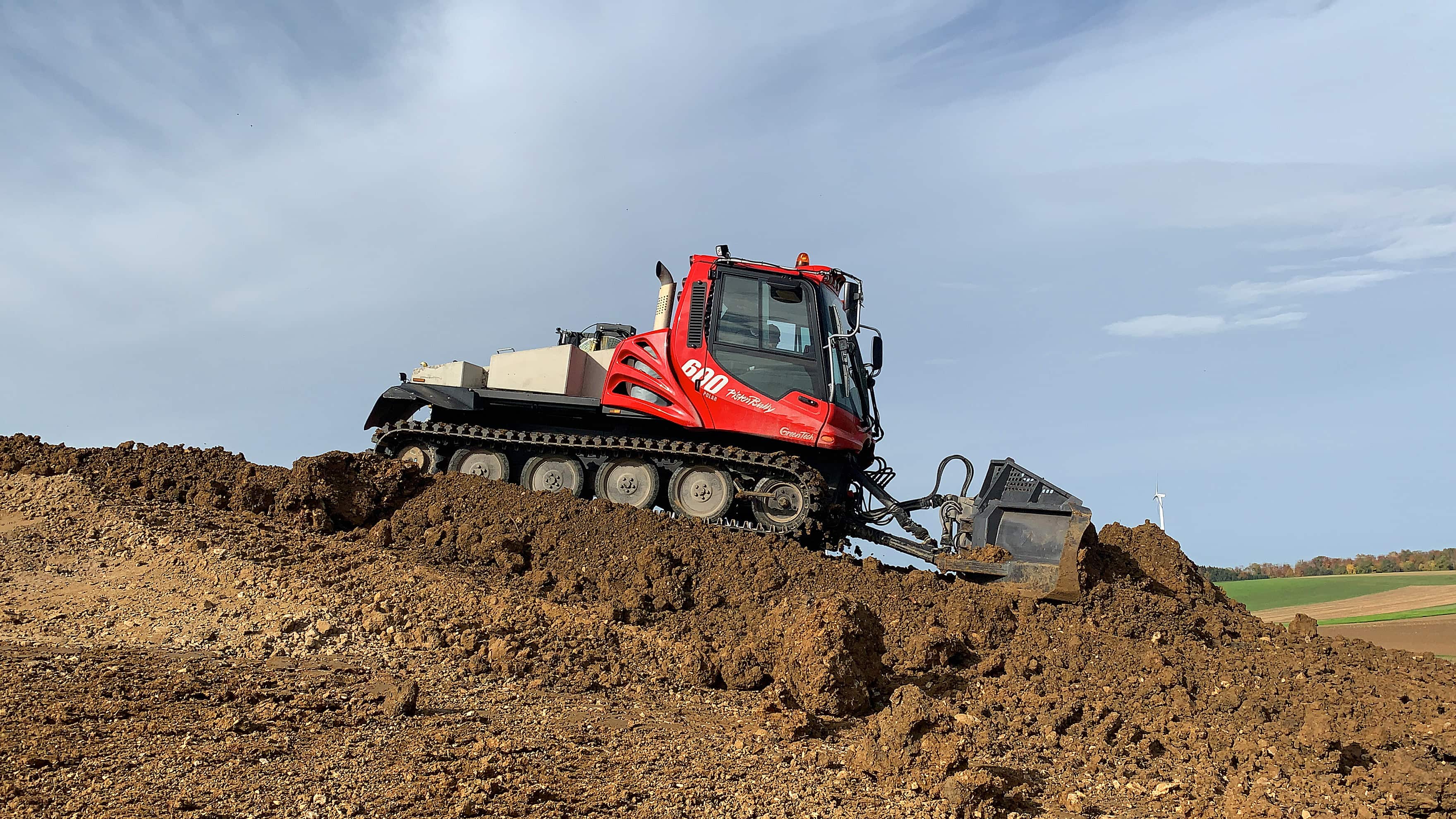 PistenBully 600 Polar GreenTech moving soil.