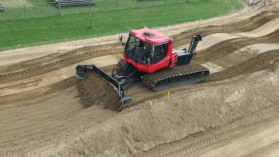 A PistenBully building a motocross race course. 