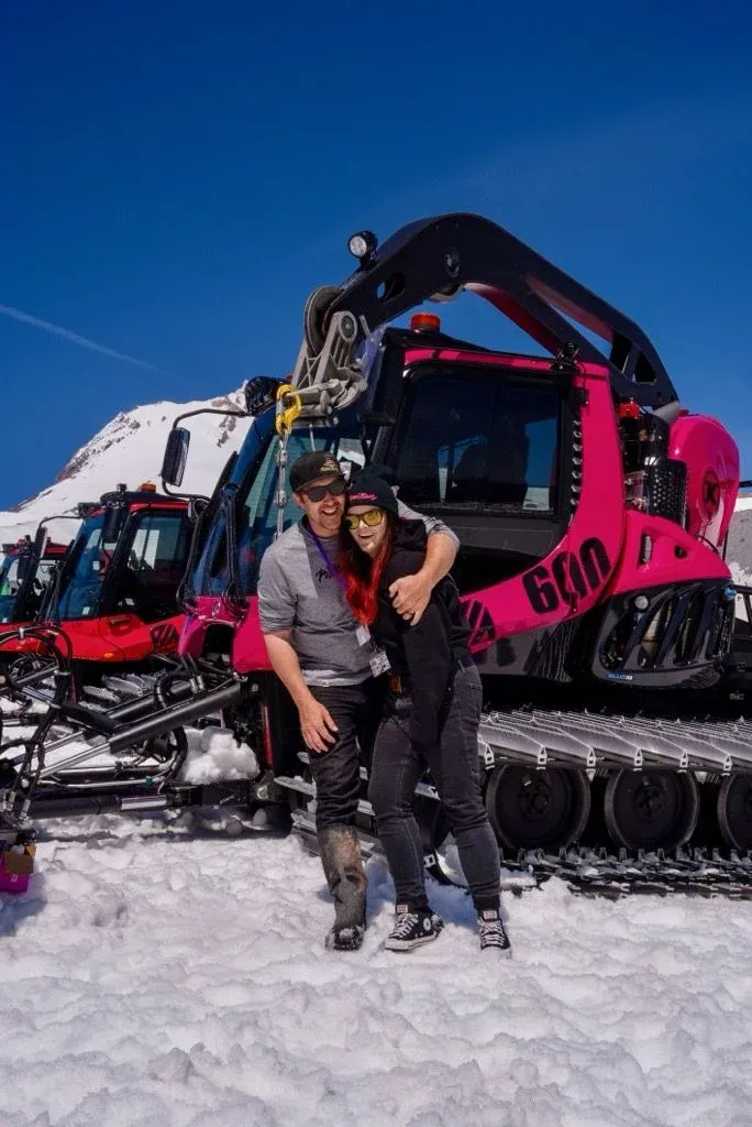 Jeff and Whitney in front of the pink PistenBully.