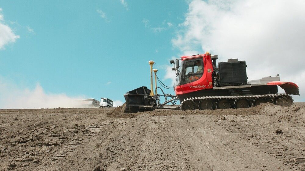 PistenBully 300 Polar GreenTech beim Verschieben von Kies.