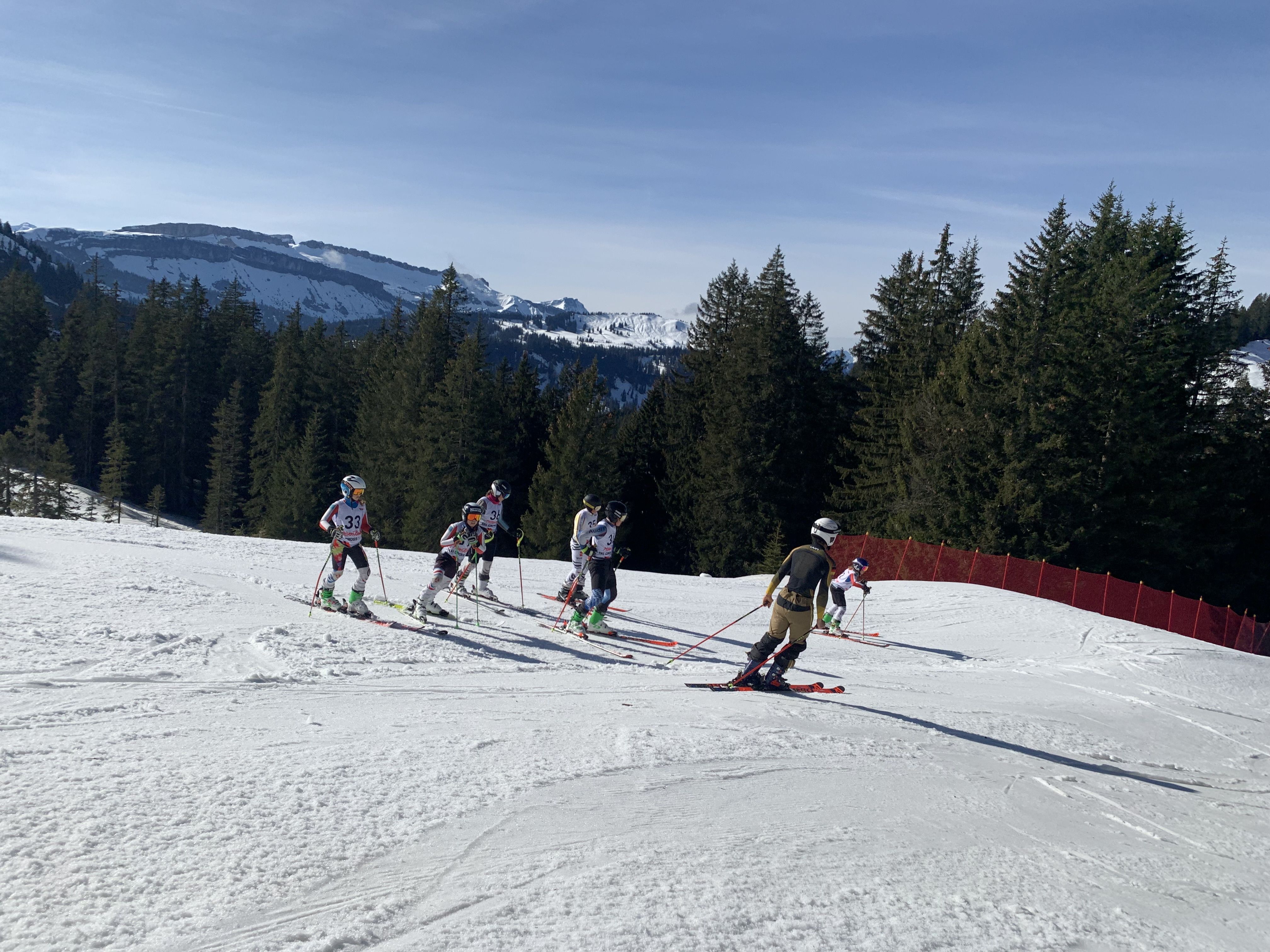 Die Kids fahren die Skicross Strecke hinunter
