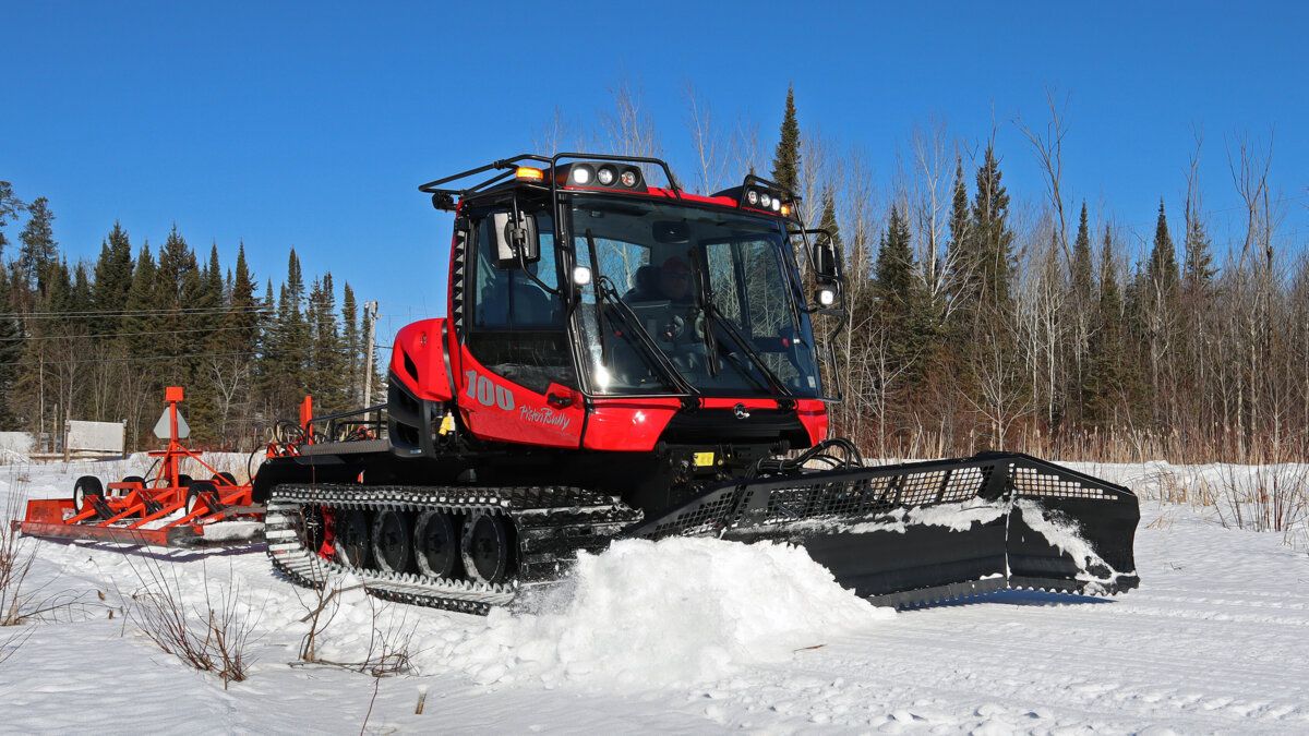 A PistenBully trail machine maintaining a snowmobile course.